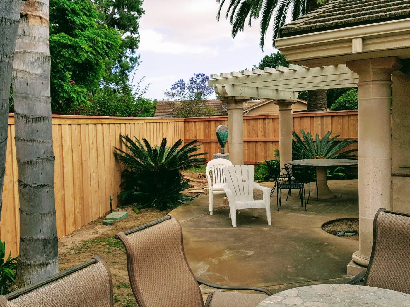 A new cedar fence running along the boundary of a Lakeside backyard patio